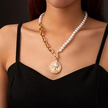 Detail of a vintage-style coin pendant with pearls and a mixed gold chain necklace