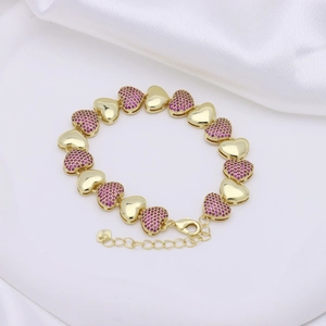 Bracciale a catena dorato con cuori in zirconia magenta su sfondo di seta bianca liscia