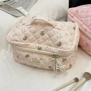Detailed view of pink quilted cotton makeup bag with cute rabbit pattern and top handle