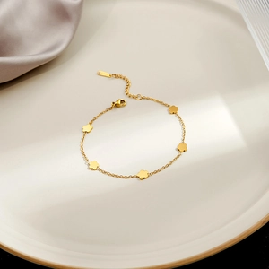 Detail of gold floral bracelet with five flower charms and adjustable lobster clasp closure