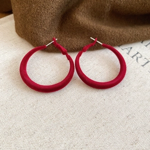 Gros plan sur de grandes boucles d'oreilles rondes floquées rouges avec tiges dorées