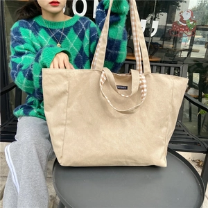 Outdoor shot of a canvas tote bag featuring stylish checkerboard pattern handles