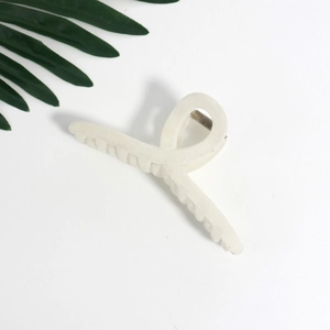 Close-up of pearl white hair claw clip with subtle glitter finish and metal spring