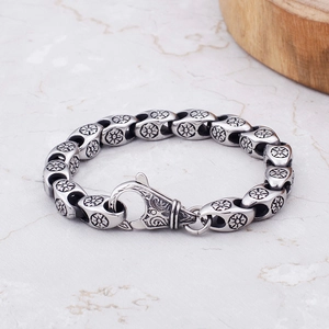 Close-up of vintage steel chain bracelet with cross flower patterns and engraved clasp