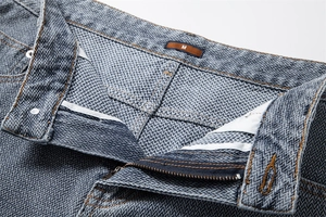 Macro shot of M size label and herringbone texture on light blue denim shorts