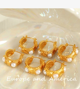 Detail view of 18k gold plated stainless steel C-shaped earrings with hammered texture and pearls