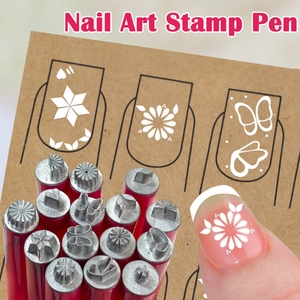 Detail showing various nail art stamp patterns like flowers and hearts on paper and nails