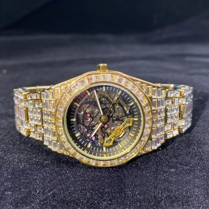Detailed close-up of a gold luxury skeleton watch encrusted with rectangular diamonds