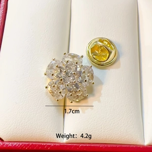 Macro view of a 1.7cm golden flower brooch with oval zircons and back clasp
