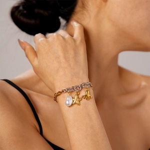 Detail of beach bracelet with baroque pearl, golden starfish, and octopus charms