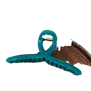Peacock blue matte resin large hair claw clip with elegant twisted cross design for women