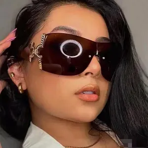 Close-up of Y2K wraparound sunglasses with rhinestone-encrusted gold metal temple joints