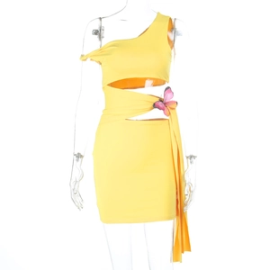 Détail d'une robe jaune à une épaule avec découpe à la taille et papillon rose