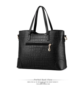 Detail view of black crocodile pattern tote bag featuring back zipper and gold hardware