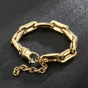 Macro detail of gold chunky pig nose chain with polished links and oversized lobster clasp