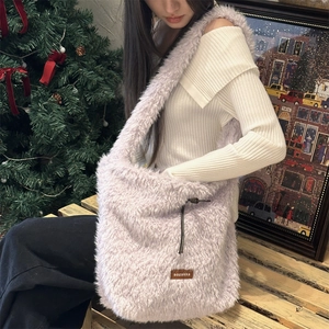 Close-up of fluffy purple fleece tote bag with black drawstring and logo leather patch