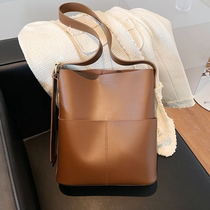 Detail einer braunen Leder-Eimertasche mit glatter Textur und präziser Nahtverarbeitung