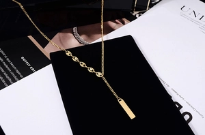 Detail view of gold 18K plated lucky charm necklace with rectangle pendant and pig nose buckle