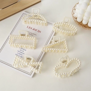 Detailed collection of elegant cream pearl hair claws in butterfly and heart shapes