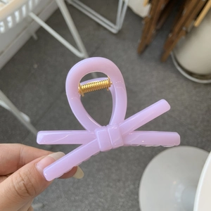 Close-up of a lavender bow hair claw clip with a durable gold metal spring mechanism