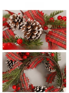 Close-up of artificial pine needles, red berries, and snow-tipped pinecones on Christmas wreath