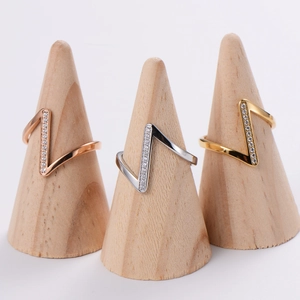 Classic V-shaped diamond rings in rose gold, silver, and gold on wooden stands