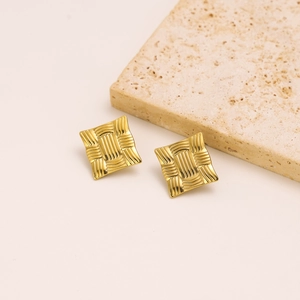 Detail shot of golden square stud earrings featuring a unique woven texture on stone