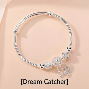 Adjustable sterling silver dreamcatcher bracelet with heart center and feather pendants