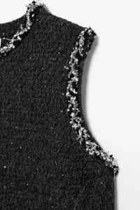 Detail of black sequined tweed dress with elegant silver beaded woven trim on edges
