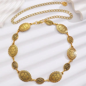 Close-up of bohemian metal waist chain with antique gold engraved circular links