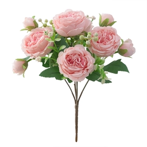 Close-up of artificial flower bouquet with four large and three small pink roses and leaves