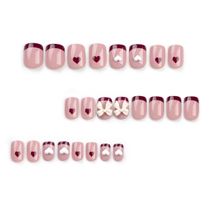 French style press-on nails with red heart patterns and 3D white bowknot accents