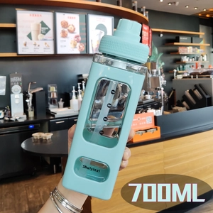 Close-up of a 700ML blue square water bottle featuring volume markers and a straw