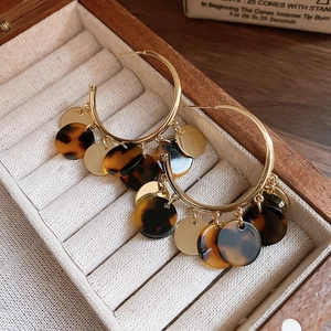 Close-up of vintage leopard print hoop earrings with golden metal accents on velvet