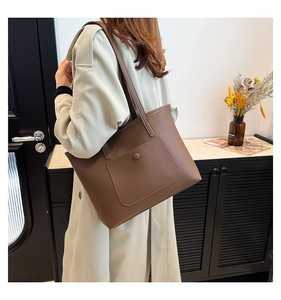 Detail of dark brown leather tote bag showing side view and premium matte texture