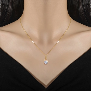 Elegant gold titanium necklace featuring a sparkling pear-shaped zircon pendant on a model