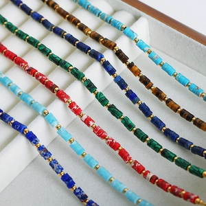 Handmade beaded necklaces set with natural stones and gold spacers on a beige velvet tray