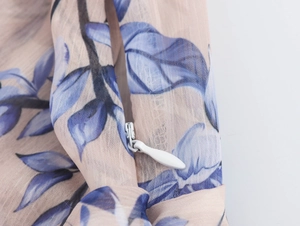 Détail de la fermeture éclair invisible sur une robe en mousseline à fleurs bleues