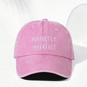 Close-up of white perfectly imperfect embroidery on washed pink cotton baseball cap