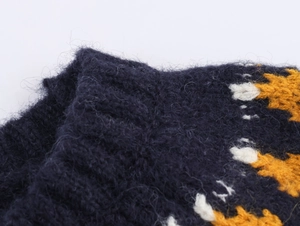 Close-up of fuzzy navy knit sweater with yellow floral jacquard and mohair texture