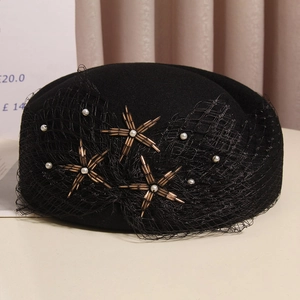 Detailed shot of black wool beret with delicate mesh veil and pearl star embellishments
