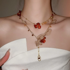 Detail of double-layer vintage necklace with acrylic petals and floral fabric accents