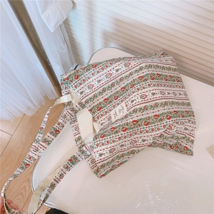 Detailansicht der Stofftasche mit dichtem Blumenmuster und robusten Baumwollgriffen