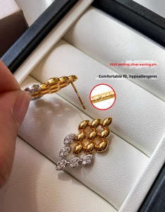 Gros plan des boucles d'oreilles losanges en argent S925 avec zircons scintillants