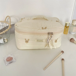 Close-up of cute rabbit embroidery on quilted cotton cosmetic bag with dual zippers