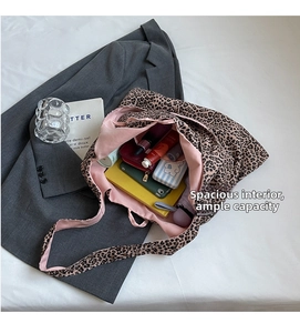 Detailed view of large leopard print tote bag interior with pink lining and daily essentials
