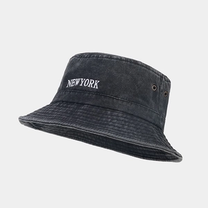 Detail of washed cotton bucket hat featuring New York embroidery and metal eyelets