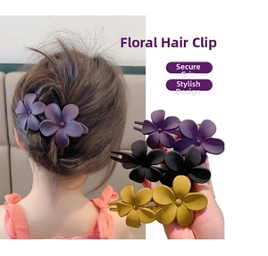 Détail de pinces à cheveux fleurs mates en violet, noir et jaune pour coiffures élégantes