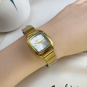 Detail shot of the vintage square gold alloy watch featuring a white Roman numeral dial