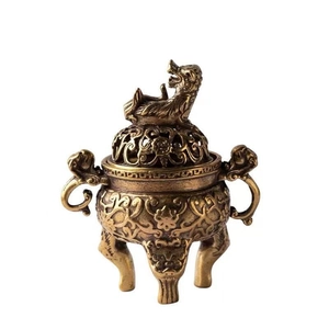 Detail of vintage copper incense burner featuring ornate hollow carving and lucky beast lid